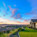 A beautiful, colorful sunset of pinks and aqua blues color the sky over a typical American subdivision on a hillside in Spokane, Washington