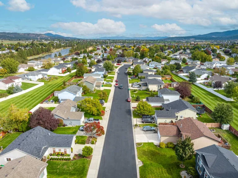 An aerial view on a sunny day of a typical Spokane, WA neighborhood|Safety precautions take around a trenched plumbing excavation in Spokane WA|Plumbing excavation in a yard to expose the existing pipes to replace them
