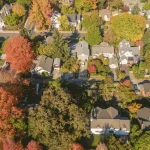 An aerial view of a neighborhood in Washington State|Newly installed indoor furnace and air handler system connected to ductwork in Spokane Valley home|Newly installed outdoor heat pump unit on concrete pad beside Spokane Valley home