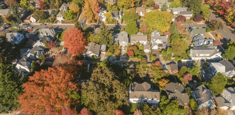 An aerial view of a neighborhood in Washington State|Newly installed indoor furnace and air handler system connected to ductwork in Spokane Valley home|Newly installed outdoor heat pump unit on concrete pad beside Spokane Valley home