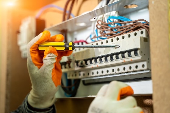 An up close photo of an electrician working on a panel