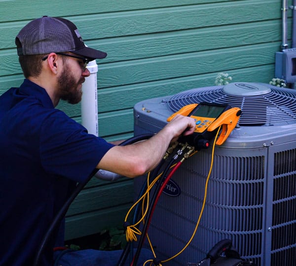 HVAC technician repairs air conditioner in Spokane