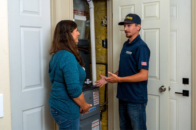 HVAC technician explains the heating system functions to a customer