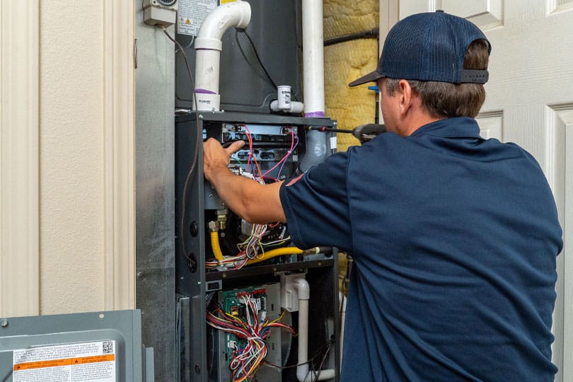 HVAC technician installs new high-efficiency furnace