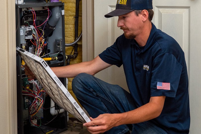 HVAC tech inspects a heating system air filter