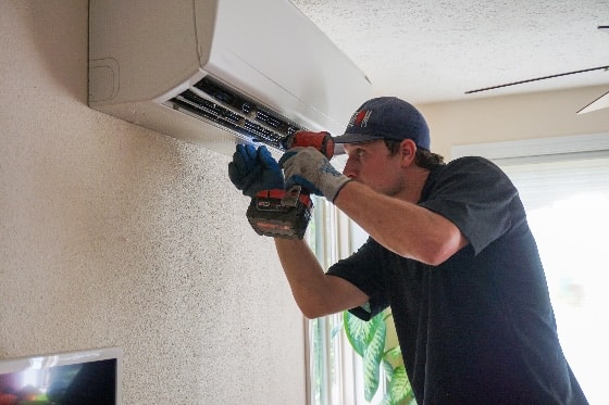 A Mainstream HVAC technician installing a ductless mini split in a home