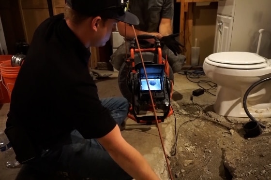 A Mainstream plumber conducting a sewer camera inspection in a home.
