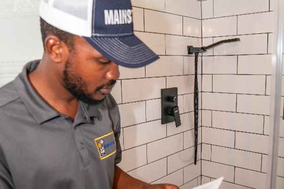 A Mainstream plumber conducting an audit of a bathroom shower.