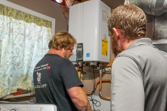 A Mainstream plumber working on installing a tankless water heater in a home