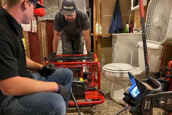 Mainstream Plumbers Working Around Toilet