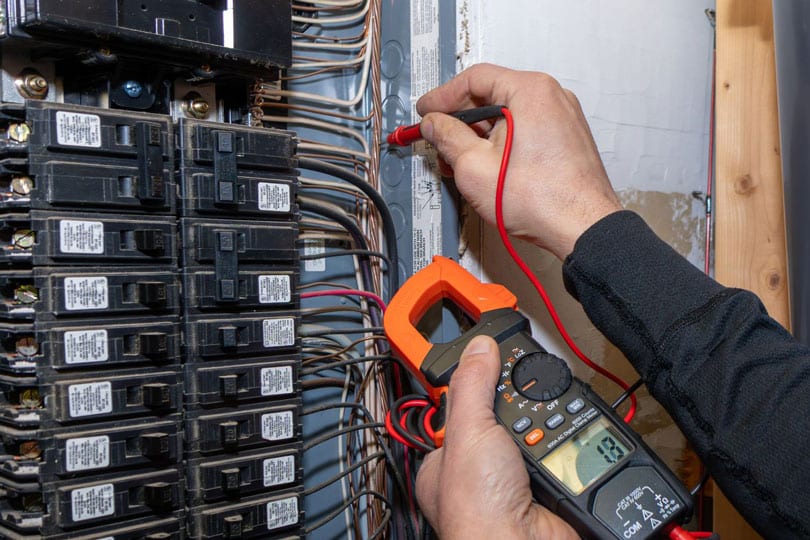 An electrician testing the circuits on an electrical panel