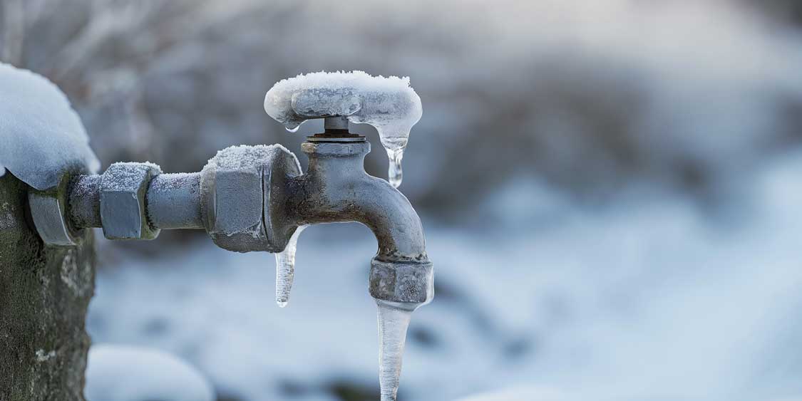 A frozen over water spigot outside on a cold winter