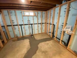 Basement plumbing repipe completed with concrete restored and new piping neatly installed behind framed walls.