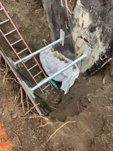 Plumbing excavation in a yard to expose the existing pipes to replace them