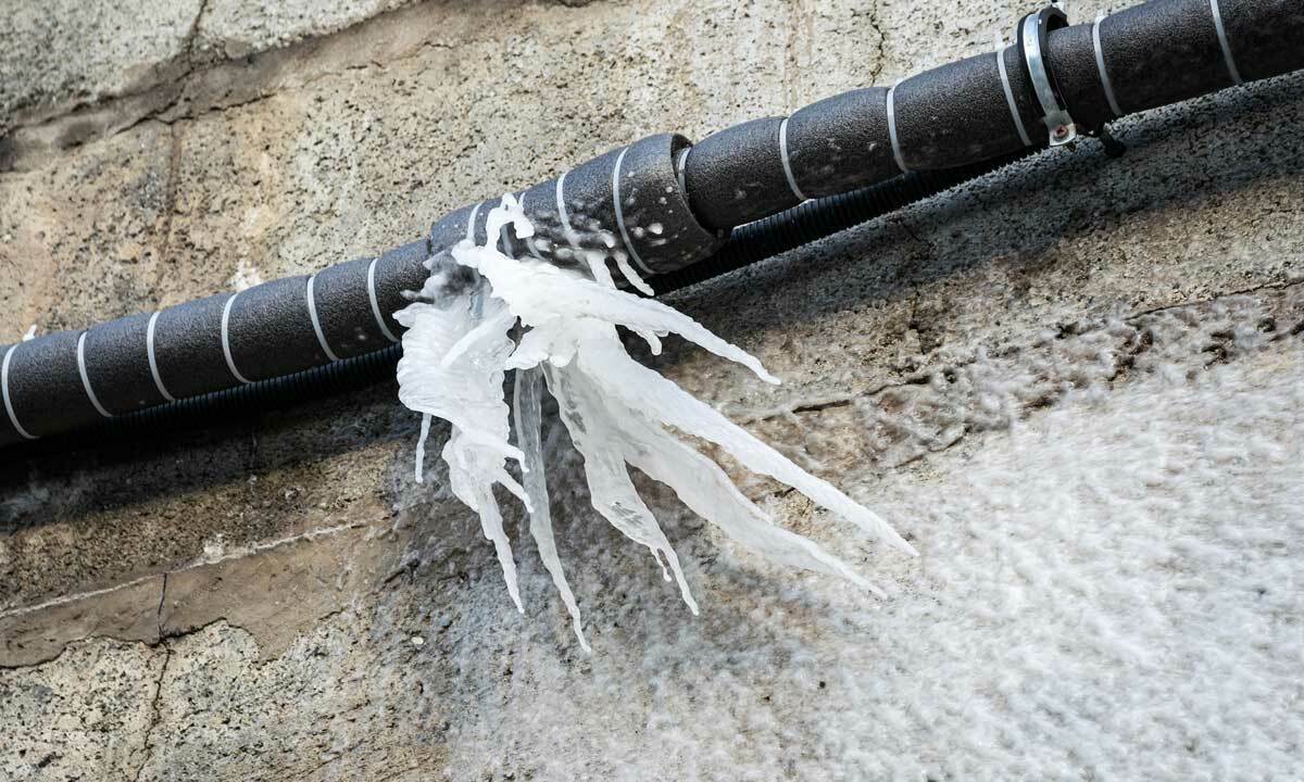 Frozen pipes with icicles coming from them.