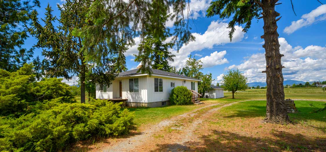 A typical white farmhouse located in rural Spokane Valley, WA area.