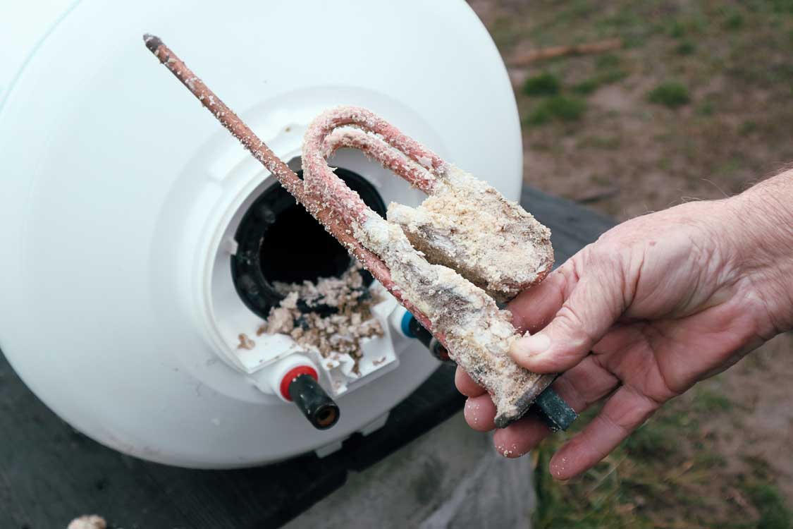 The heating element covered with sediment from a water heater