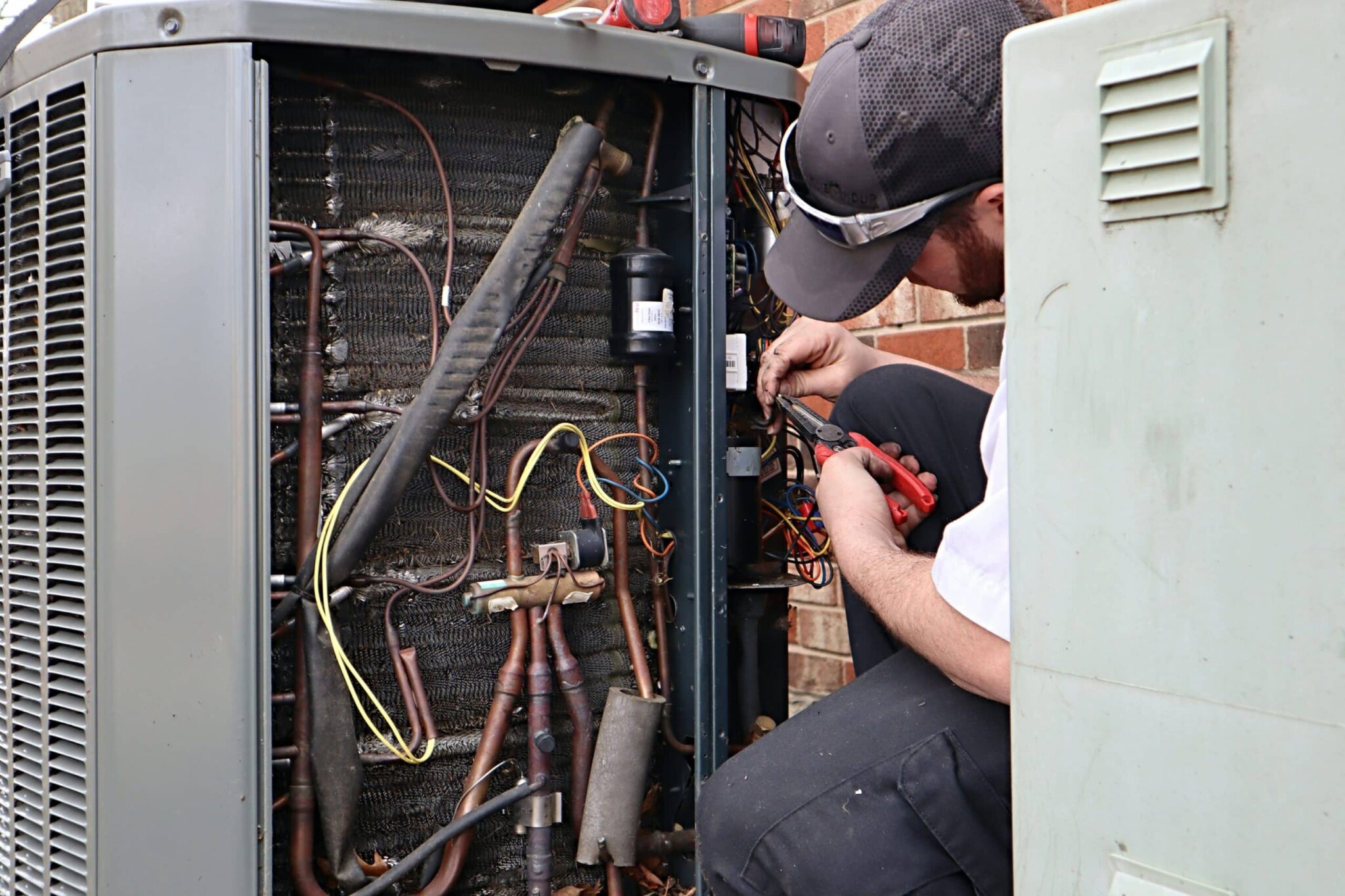 HVAC technician repairing an outdoor AC unit